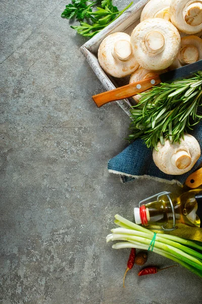 Çiğ mantarlar taze otlar ve gri masada baharat.