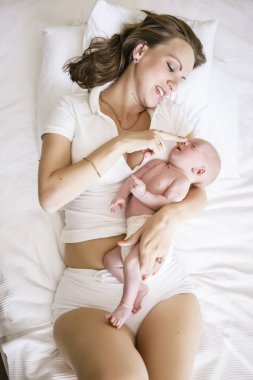 Hafif bir arka plan üzerinde yeni doğan oğlu olan anne