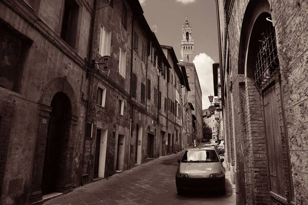 Street view with old buildings and bell tower in Siena, Italy.