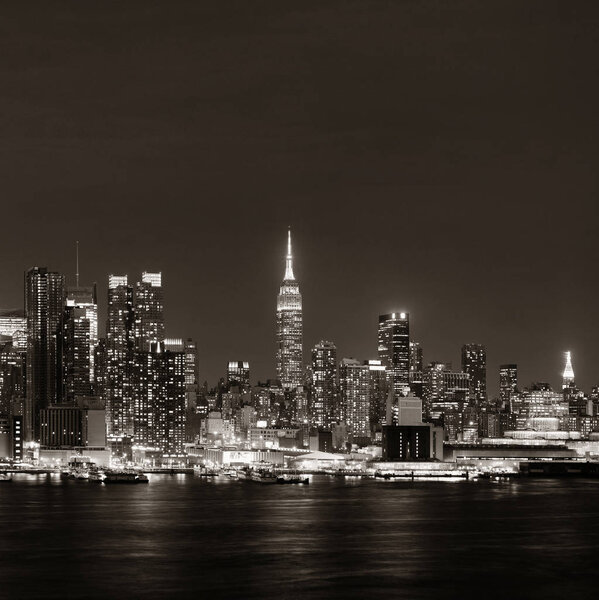 Midtown skyline over Hudson River in New York City with skyscrapers at night