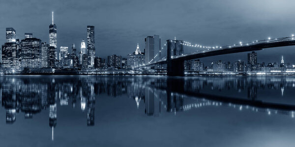 Manhattan Downtown urban view with Brooklyn bridge at night with reflections in BW