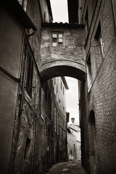 Street view with old buildings and archway in Siena, Italy.