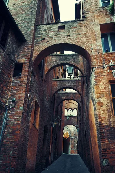 Oude gebouwen en archway in Siena — Stockfoto