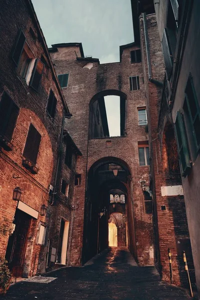 Oude gebouwen en archway in Siena — Stockfoto