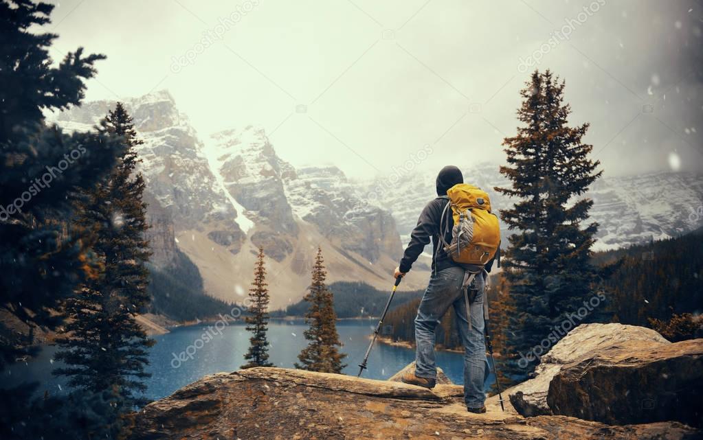 Hiker in wild with snow mountain and lake 