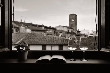 Lucca penceresi görünümü ile şarap kitap çiçek