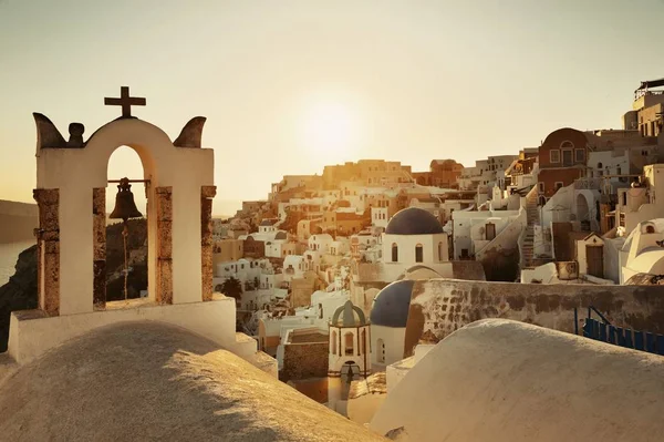 ギリシャに教会の鐘と建物とSantoriniスカイラインの夕日 — ストック写真