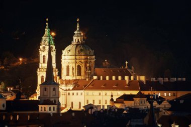 Geceleri Çek Cumhuriyeti 'nde kilise ve kubbeli Prag silueti manzarası.