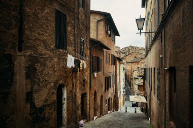 Siena, İtalya 'da eski binalarla sokak manzarası.