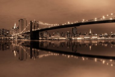 Brooklyn Köprüsü'nün yansımaları ile gece Manhattan Downtown kent manzaralı