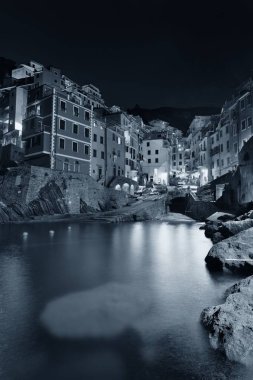 Riomaggiore rıhtımı siyah beyaz manzaralı Cinque Terre 'de geceleri binalar, İtalya.