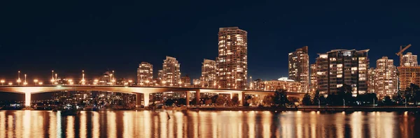 Vancouver city skyline at night view with buildings and bridge.