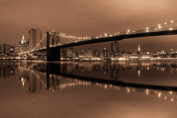 Manhattan Downtown urban view with Brooklyn bridge at night with reflections
