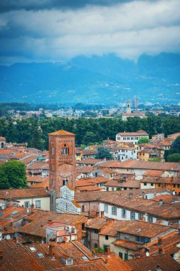 Lucca çatı görünümü ile kırmızı çatılar ve çan kulesi, tarihi binaları ve dağ silsilesi İtalya.