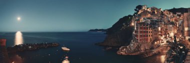 Riomaggiore rıhtım manzaralı binalar ve ay batımı Cinque Terre 'de gece panoraması, İtalya.