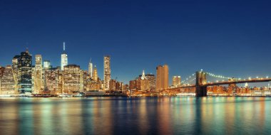 Brooklyn Köprüsü ve New York City'deki gece şehir merkezindeki Manhattan siluetinin