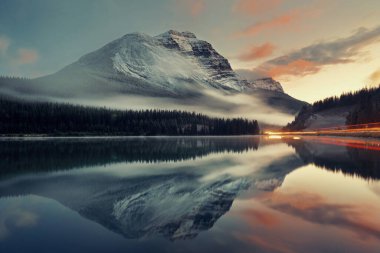 Dağ Gölü ve trafik ışığı izi yansıma ve gün batımında siste Banff National Park, Amerika Birleşik Devletleri.