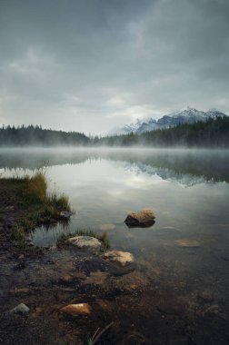 Herbert Gölü buzullarla dolu sisli bir sabah ve Kanada Banff Ulusal Parkı 'nda yansıması var.