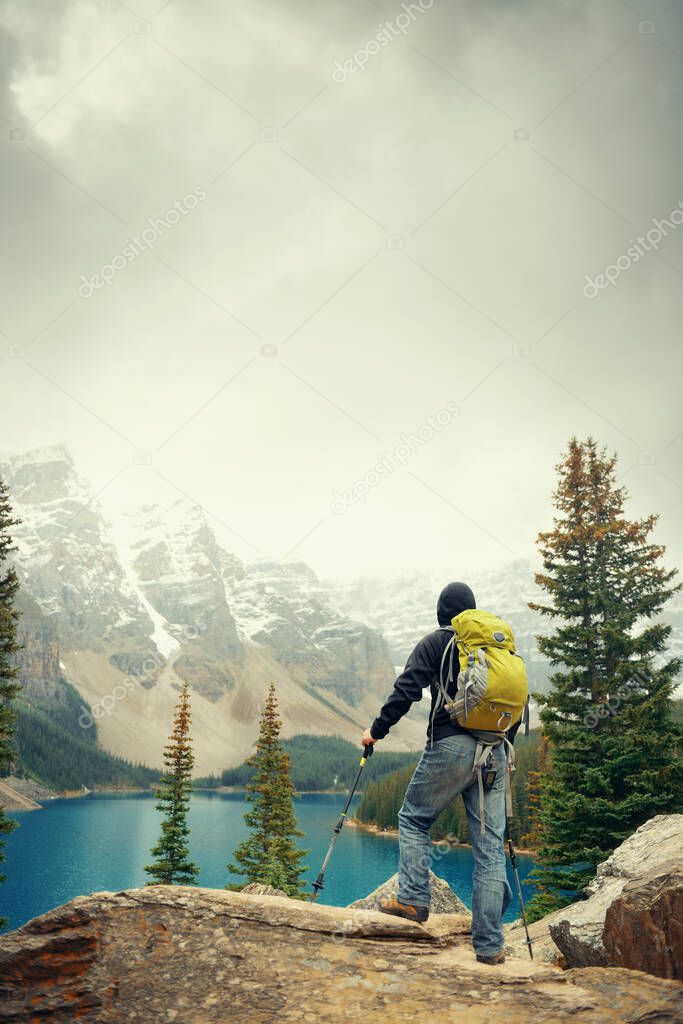 Hiker in Moraine Lake with snow capped mountain of Banff National Park in Canada