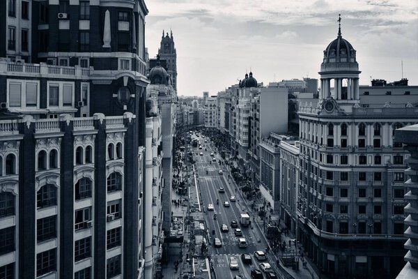 Business shopping area on Gran Via with historical buildings and traffic in Madrid, Spain.