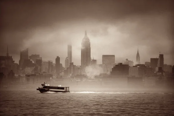 Midtown Manhattan skyscrapers and boat in fog in New York City