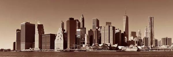 Manhattan financial district with skyscrapers over East River in BW.