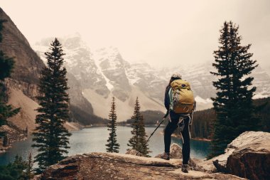 Moraine Gölü 'ndeki yürüyüşçü Kanada' daki Banff Ulusal Parkı 'nın karlı tepesinde