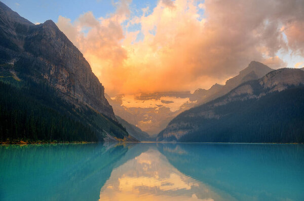 Lake Louise at sunrise in Banff national park with mountains and forest in Canada.