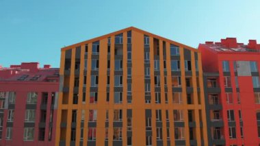 Günbatımında renkli evler üzerinde insansız hava aracı uçuşu. Comfort Town, Kiev, Ukrayna. Renkli binaları olan bir yerleşim yeri. Kamera ileri gidiyor. Hava görüntüsü, İHA video görüntüleri.