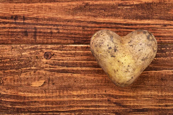 Potato heart over wooden background — Stock Photo, Image