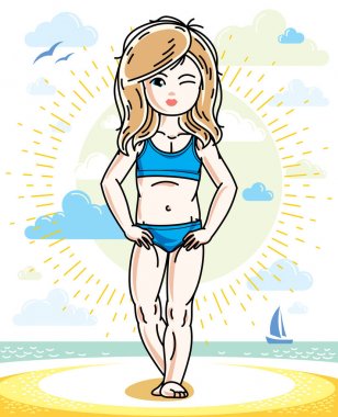 Küçük sarışın kız yürümeye başlayan güneşli kumsalda ayakta 