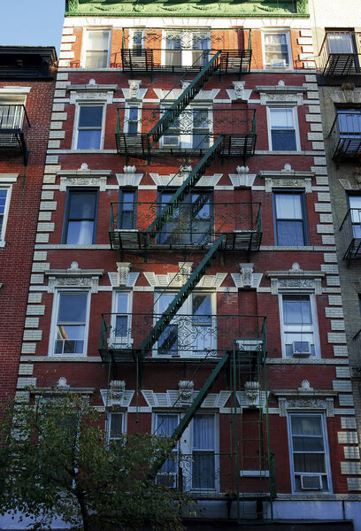 Exterior of an old building in historic part of New York City with old fire escape.