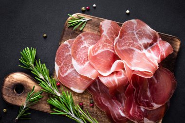 Prosciutto koyu arka plan üzerine dilimlenmiş