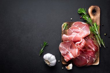 Prosciutto koyu arka plan üzerine dilimlenmiş