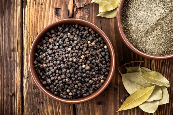 Black pepper on wooden background — Stock Photo, Image