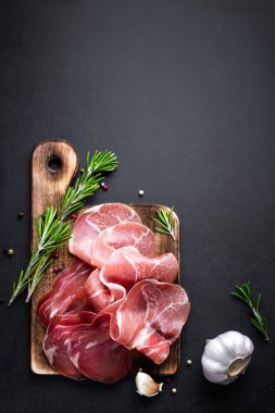 Prosciutto koyu arka plan üzerine dilimlenmiş