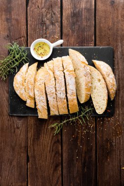 taze ev yapımı ciabatta ekmeği taş kayrak yönetim kurulu, zeytin yağı ve biberiye ahşap zemin üzerine dilimlenmiş