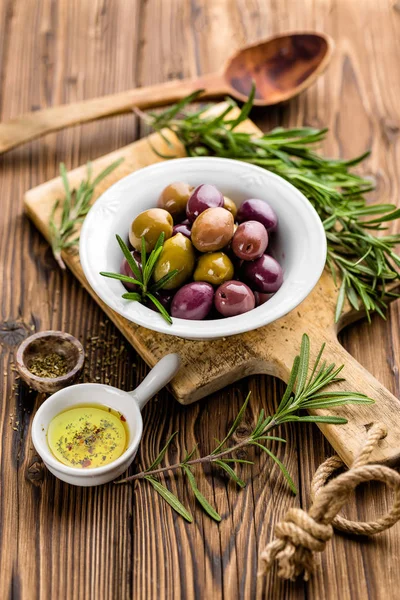 Rozemarijn, olijven, olijfolie op houten achtergrond — Stockfoto