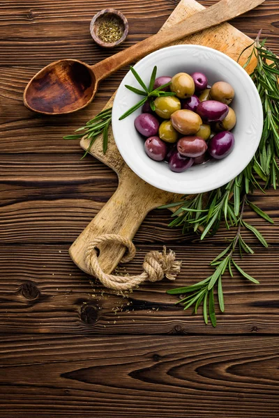 Rozemarijn, olijven, olijfolie op houten achtergrond — Stockfoto