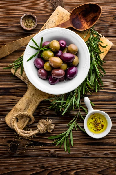 Romero, aceitunas, aceite de oliva sobre fondo de madera —  Fotos de Stock