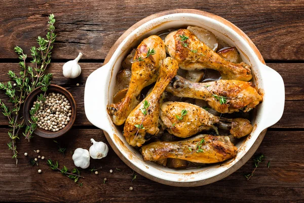 Pernas de frango assadas em fundo de madeira rústica — Fotografia de Stock