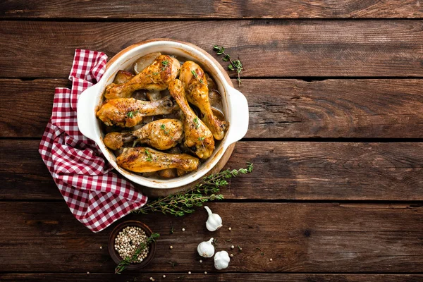 Pernas de frango assadas em fundo de madeira rústica — Fotografia de Stock