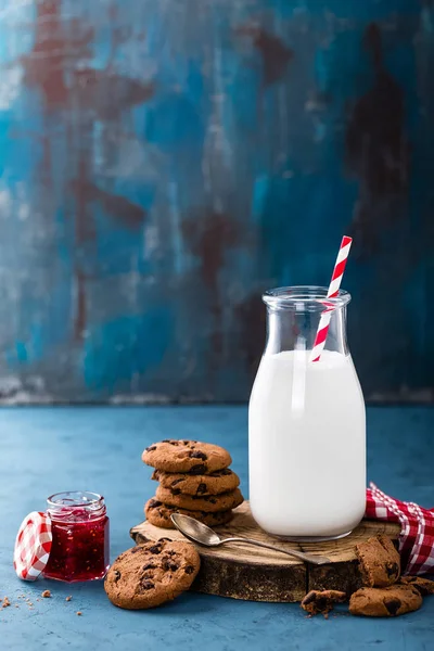 Melk in glazen fles op blauwe achtergrond — Stockfoto