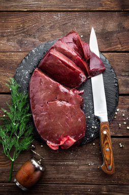 Ahşap arka plan üzerinde kayrak gemide pişmemiş karaciğer