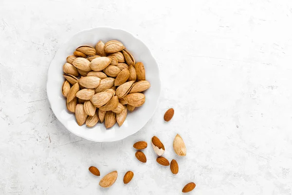 Nueces de almendra sobre fondo blanco directamente encima de la posición plana —  Fotos de Stock