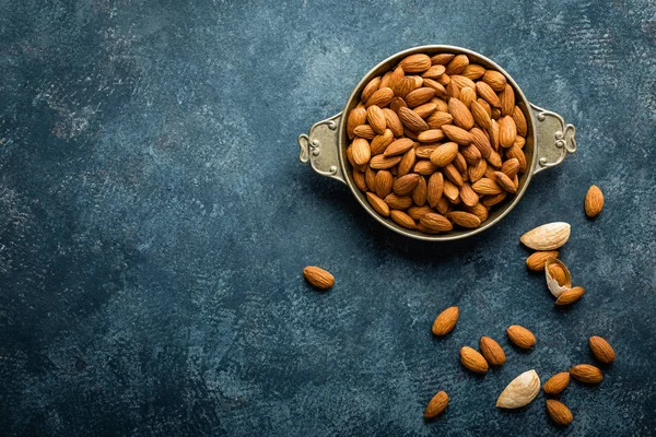 Almond nuts on dark background directly above copy space flat lay — Stock Photo, Image