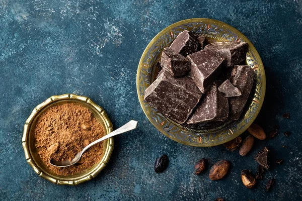 Donkere chocolade stukken gebroken en cacao bonen, culinaire achtergrond, direct boven — Stockfoto
