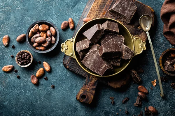 Piezas de chocolate negro triturado y granos de cacao, vista superior — Foto de Stock