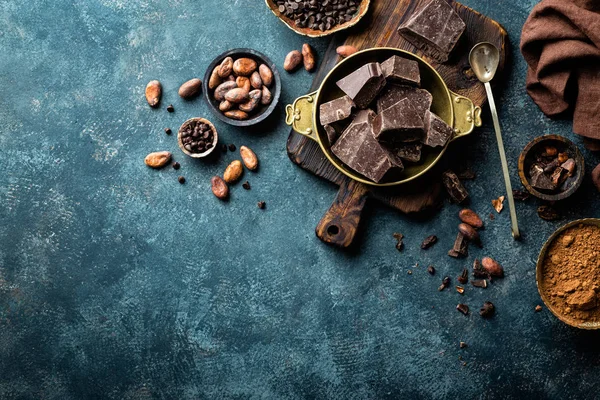 Pezzi di cioccolato fondente schiacciati e fagioli di cacao, sfondo culinario, vista dall'alto — Foto Stock