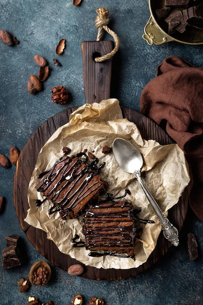 Pastel de brownie de chocolate, postre con nueces sobre fondo oscuro, directamente encima — Foto de Stock